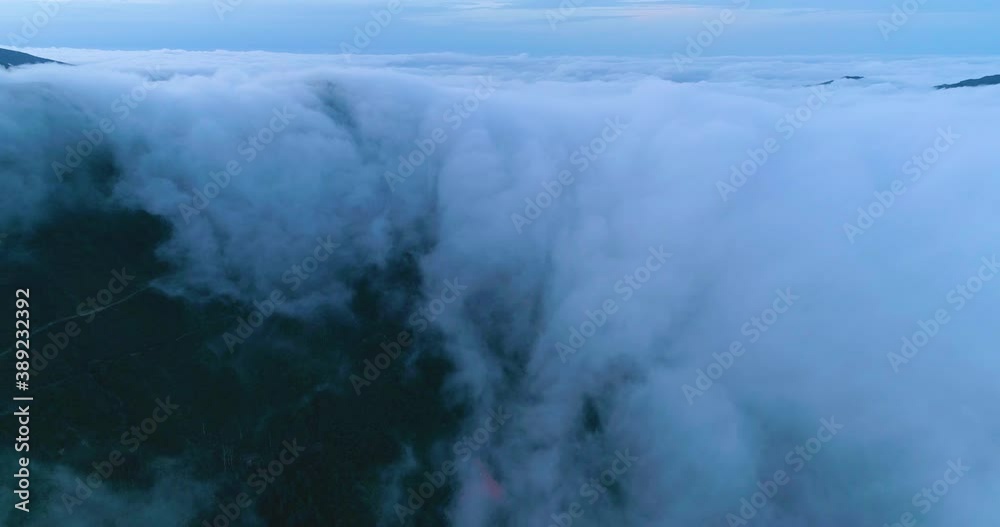 Evening scenery on the island of Madeira. Clouds flow from the mountains into the valley. Aerial view. Evening scenery on the island of Madeira. Clouds flow from the mountains into the valley. Aerial view.