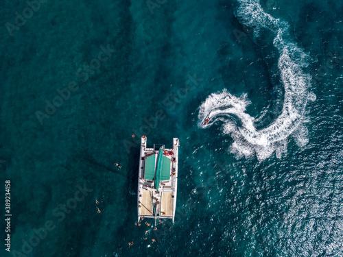 Bilde på lerret Aerial view of a catamaran with person on board and in the sea swimming, near the coasts of the island of Lanzarote, Canary, Spain
