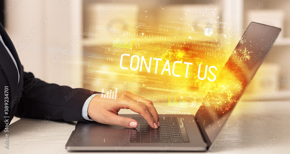 Closeup of businessman hands working on laptop with CONTACT US inscription, succesfull business concept Closeup of businessman hands working on laptop with CONTACT US inscription, succesfull business concept