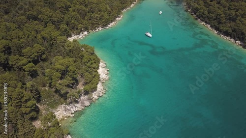 Drone shot revealing bay with clean sea water and yacht, Rab island, Croatia.