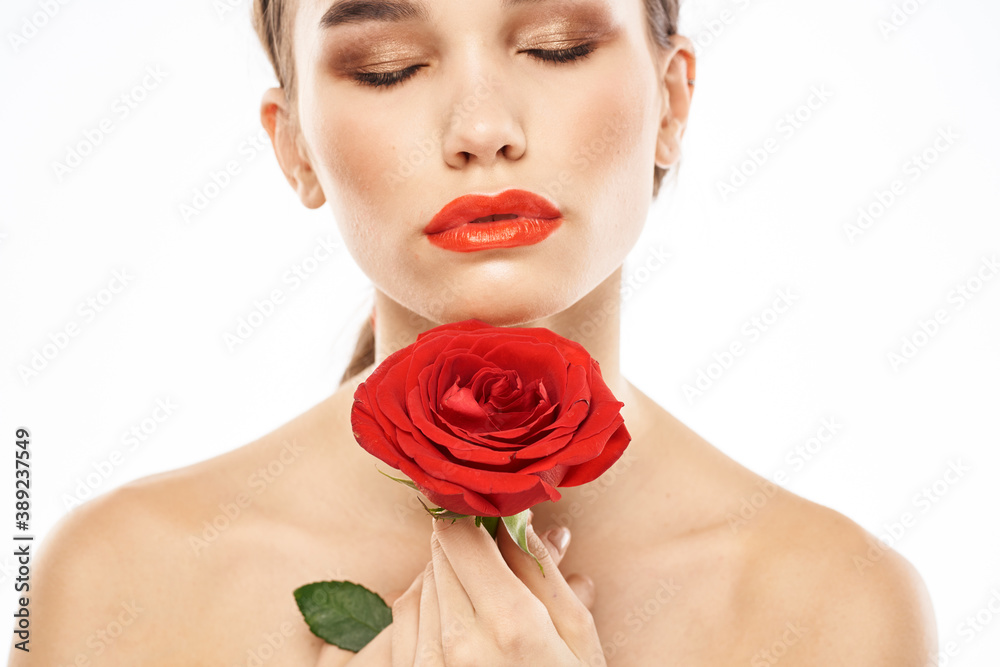 Beautiful woman with red rose near face makeup naked shoulders portrait Beautiful woman with red rose near face makeup naked shoulders portrait