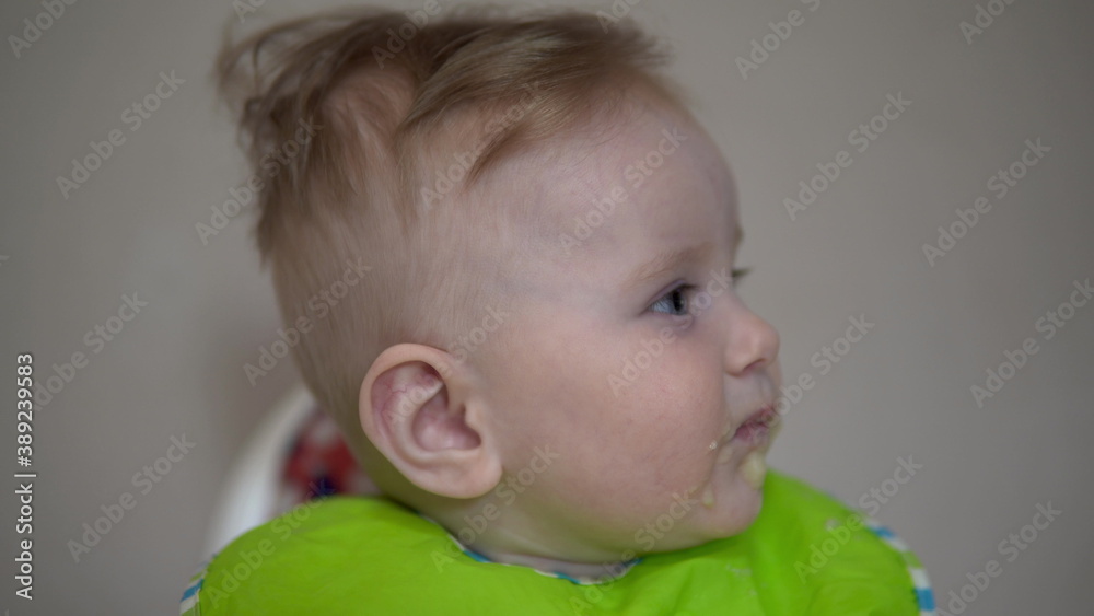 Mom feeds a small child with a spoon baby food closeup Mom feeds a small child with a spoon baby food closeup