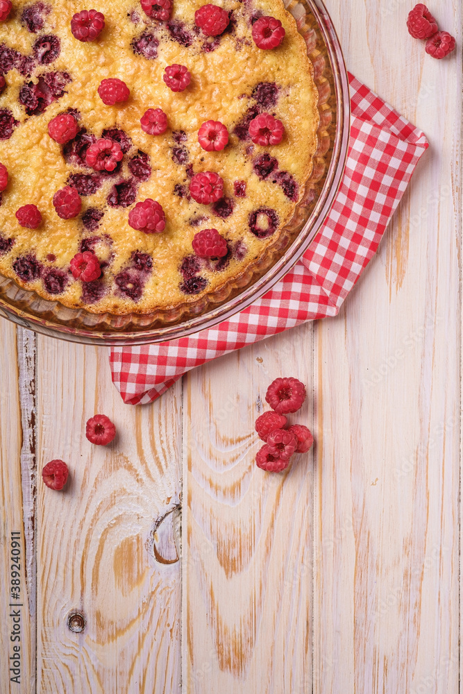 Sweet tasty pie with jellied and fresh raspberry fruits in baking dish with red tablecloth towel, wooden table background, top view Sweet tasty pie with jellied and fresh raspberry fruits in baking dish with red tablecloth towel, wooden table background, top view