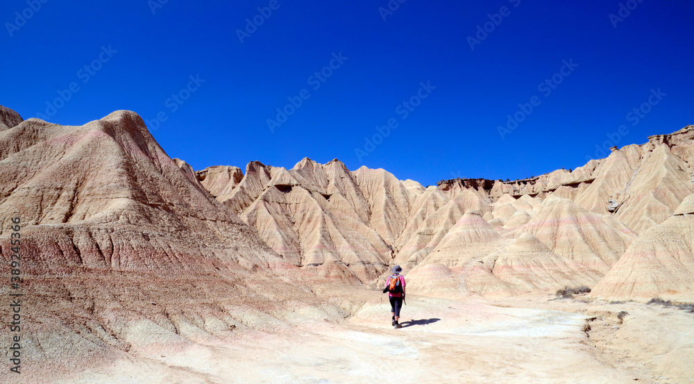 A person walks through Las Bardenas Reales, Natural Reserve and Biosphere Reserve, Navarra, Spain