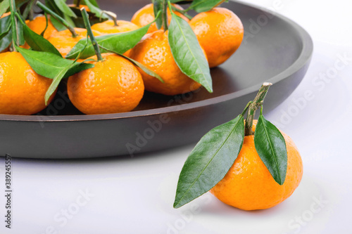 one tangerine on the background of a plate with citrus fruits