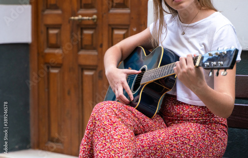 Canvas Print Young girl playing guitar in the middle of the street