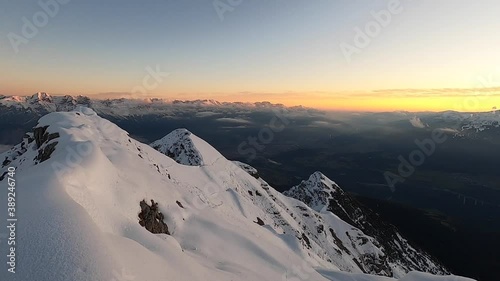 View of gorgeous pink sunrise over glacier and high mountain peaks in the Alps. The cross on top of the mountain Nockspitze. Innsbruck and the Alps are seen from the Mount.  photo