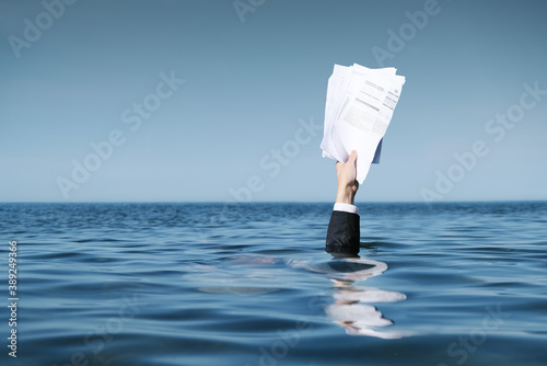 Hand Raised Above The Sea with Documents. photo