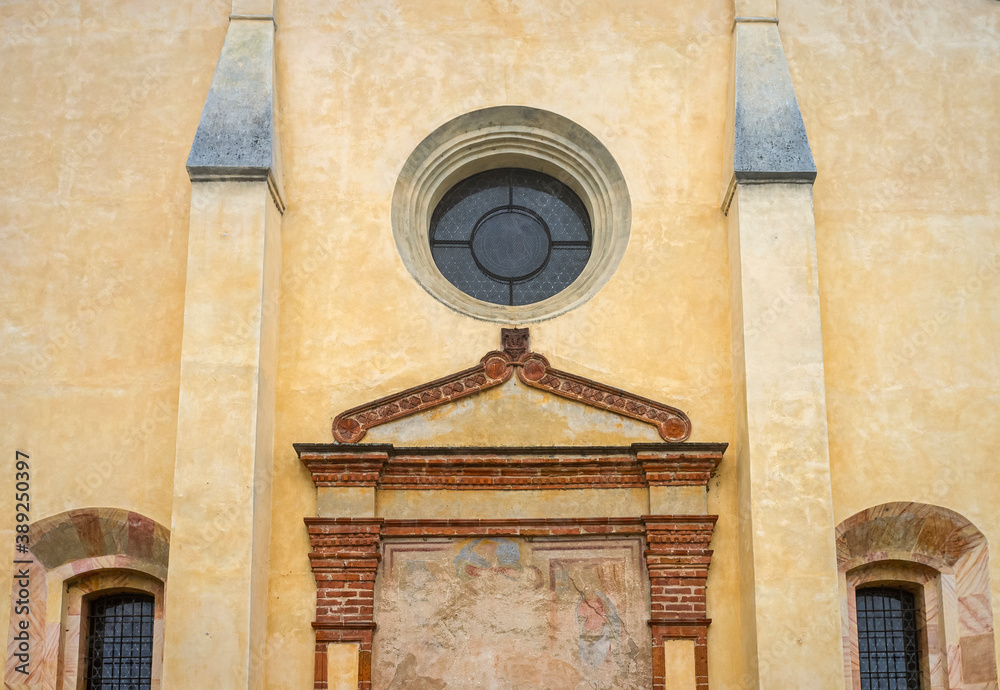 Symmetric church facade detail, in a small Italian rural village. Color image.