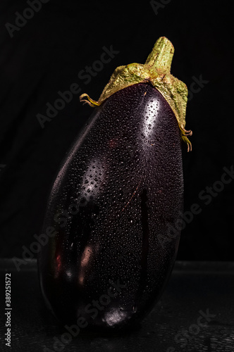 Close up wet eggplant isolated on black background