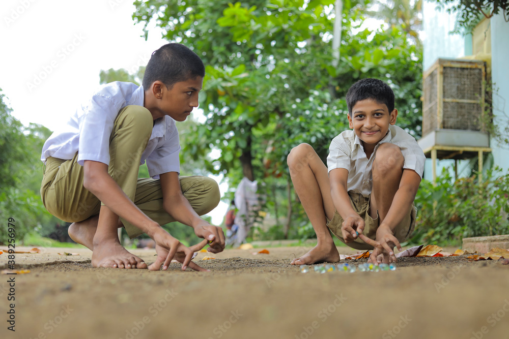Indian child playing with glass marbles which is an old Indian village