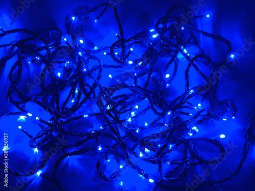 Festive christmas garland with blur / bokeh effect on blue abstract surface background.