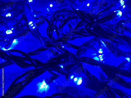 Festive christmas garland with blur / bokeh effect on blue abstract surface background.