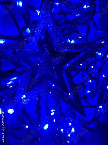 Festive christmas garland with blur / bokeh effect on blue abstract surface background.