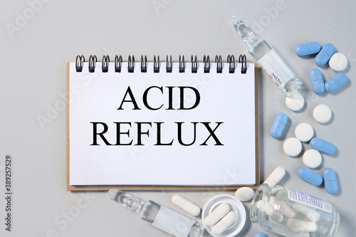 acid reflux, text on notepad on gray background near stethoscope