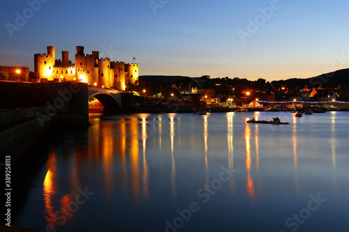 Conwy Castle floodlit against a blue Sky after Sunset, Conwy, North Wales, UK.