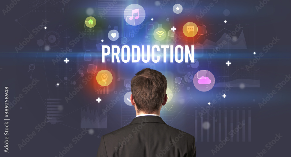 Rear view of a businessman with PRODUCTION inscription, modern technology concept Rear view of a businessman with PRODUCTION inscription, modern technology concept