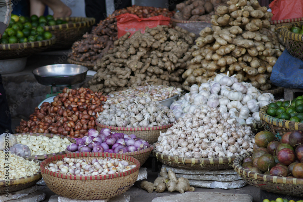 Baskets wit onions, garlic and ginger on a market in Vietnam