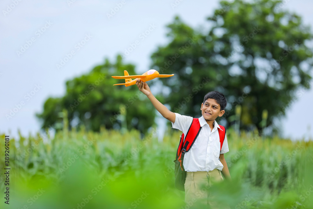 dreams of flight! indian child playing with toy airplane at green field dreams of flight! indian child playing with toy airplane at green field