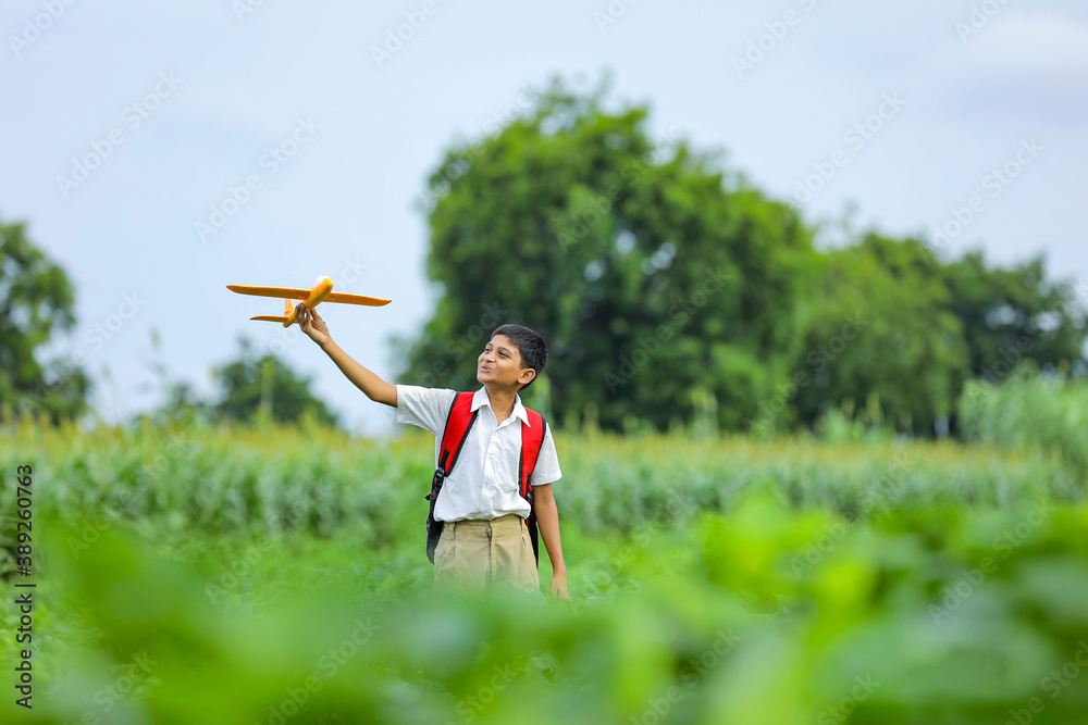 dreams of flight! indian child playing with toy airplane at green field dreams of flight! indian child playing with toy airplane at green field