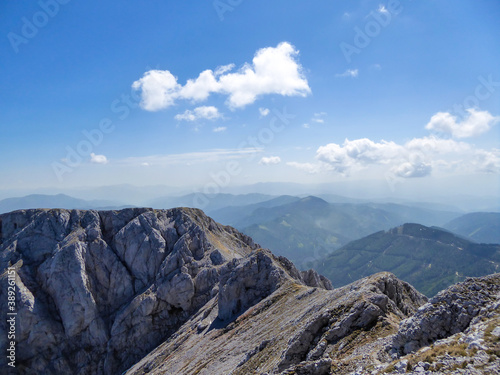 A panoramic view on a massive, stony mountains in Hochturm region, Austrian Alps. There are endless mountains chains in the back. The slopes are overgrown with moss and grass. Sunny and bright day. photo