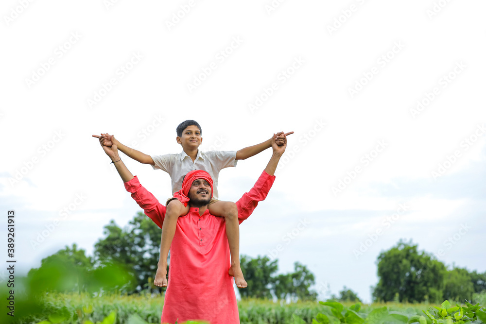 Indian farmer playing with his child at green field Indian farmer playing with his child at green field