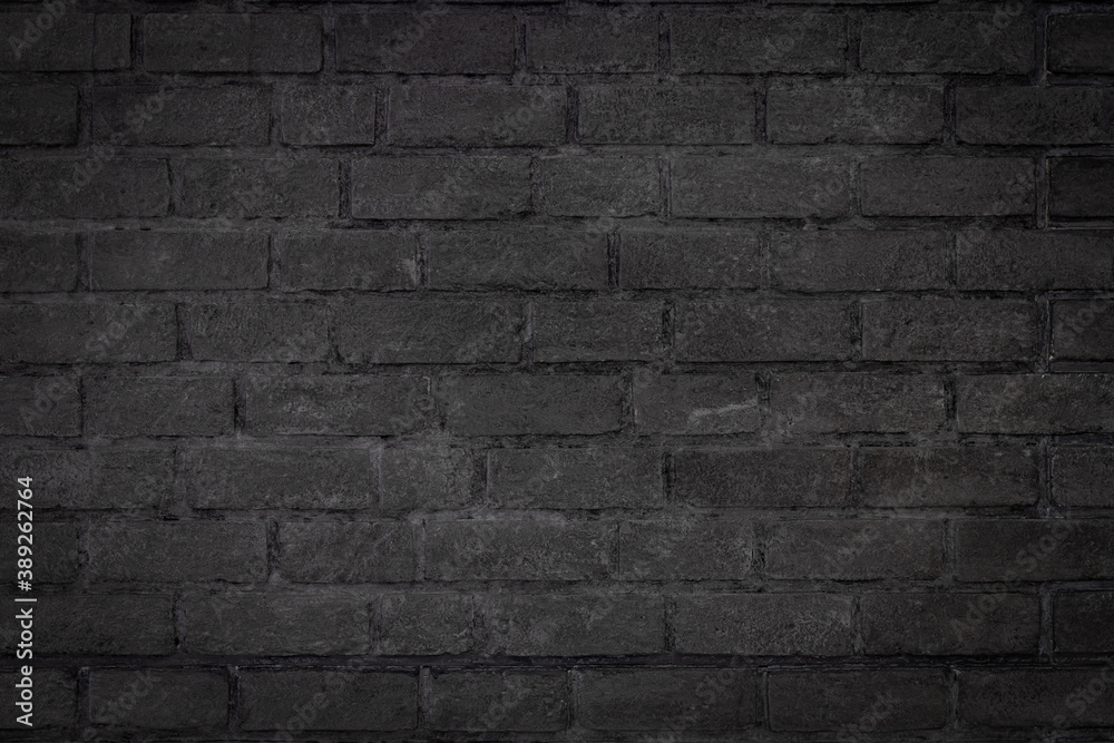Black color brick wall textured background with vignette at the edge of picture and an empty space for text.