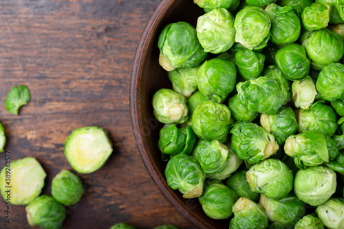 Bunch of fresh Bruxelles sprouts in a cup on wooden background. © alexshyripa
