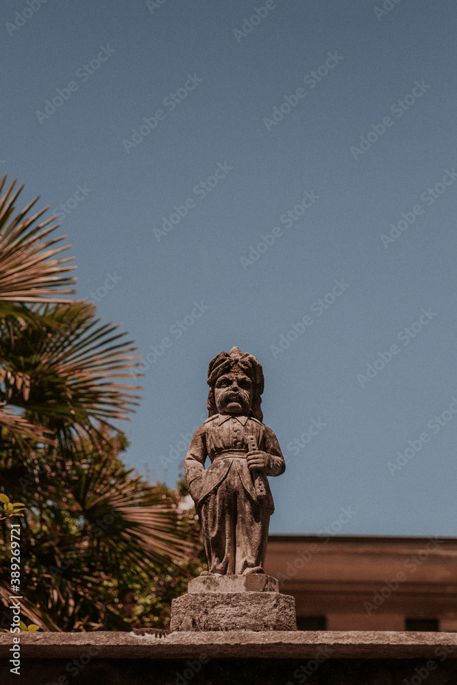 Kamienny posąg na włoskim ogrodzeniu, w tle piękne, błękitne niebo.  - obrazy, fototapety, plakaty 