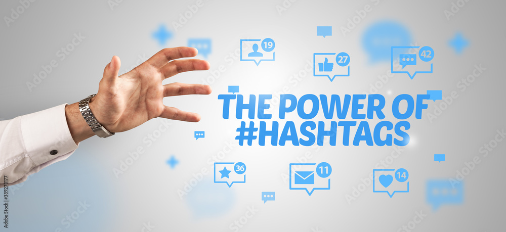 Close-Up of cropped hand pointing at THE POWER OF #HASHTAGS inscription, social networking concept Close-Up of cropped hand pointing at THE POWER OF #HASHTAGS inscription, social networking concept