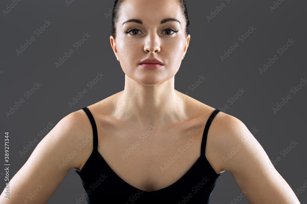 Portrait of young fitness woman, fit model looking in camera on gray background Portrait of young fitness woman, fit model looking in camera on gray background