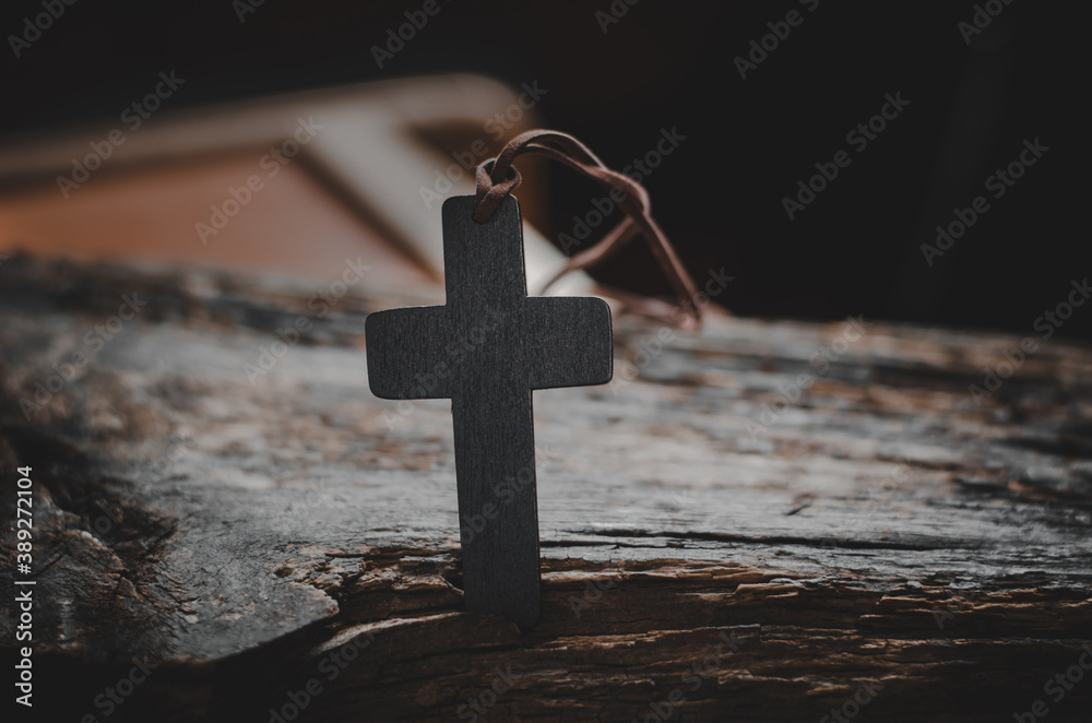 Wooden Christian cross on a wooden table. Religious concept