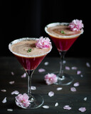 Red drinks with pink flowers on dark background.
