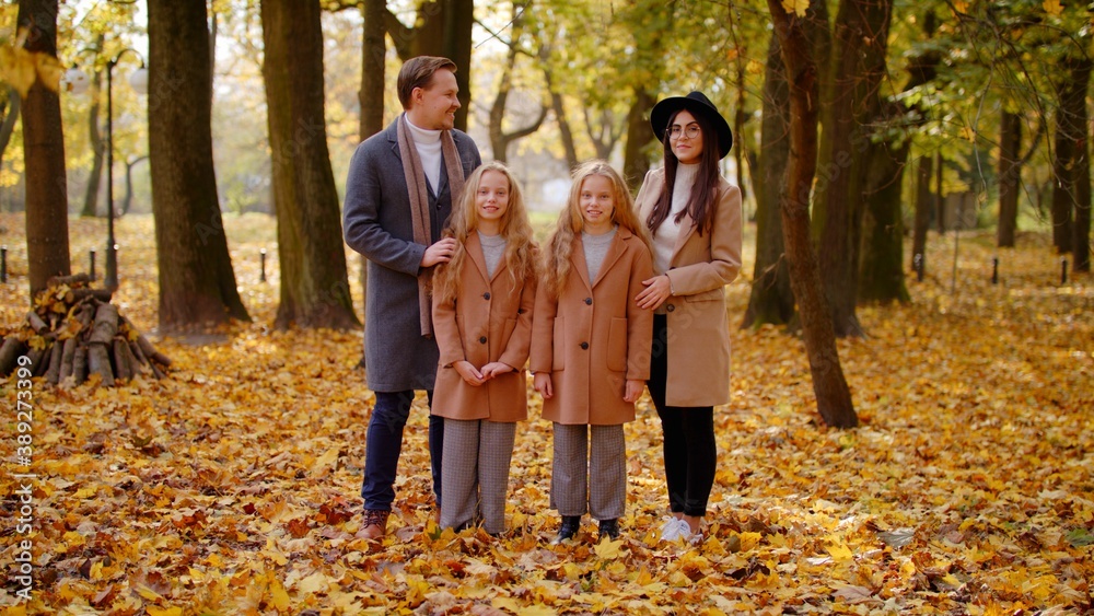 Portrait Of Happy Family On Autumn Walk. Mother Father and Children Twins In The Park Enjoying The Beautiful Autumn Nature. Friendly Family Kid Concept Autumn Countryside Portrait Of Happy Family On Autumn Walk. Mother Father and Children Twins In The Park Enjoying The Beautiful Autumn Nature. Friendly Family Kid Concept Autumn Countryside