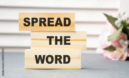 Spread the word written on a wooden block. Spread word text on white table, concept.