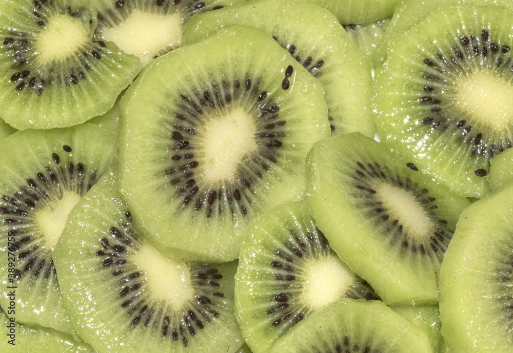 Actinidia deliciosa kiwi cut into slices with honey on top, green vegetarian dessert with radially located seeds Actinidia deliciosa kiwi cut into slices with honey on top, green vegetarian dessert with radially located seeds