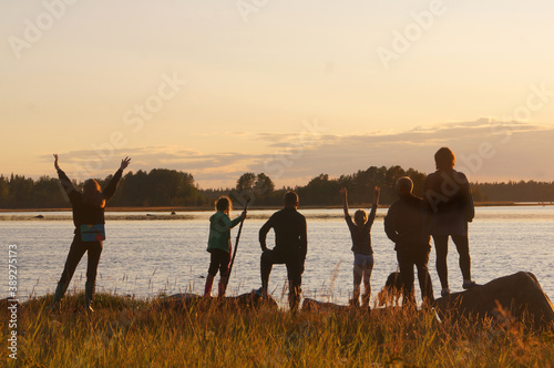family on the lake shore meets sunset silhouettes
