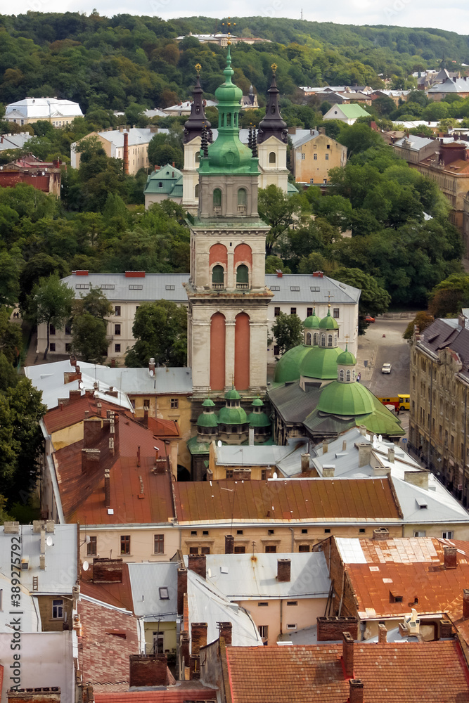 View of historical old city district of Lviv in cloudy morning, Ukraine. View of Dormition Church, Korniakt Tower. Early autumn. Old buildings and courtyards in historic Lviv