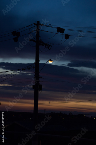 power pole. high voltage wires. urban scene at sunset