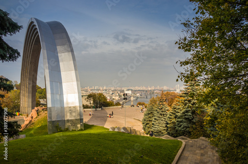 UKRAINE. KYIV - 24 OCTOBER 2020. The People's Friendship Arch is a monument in Kyiv, Ukraine. Skyline of Podol in the background