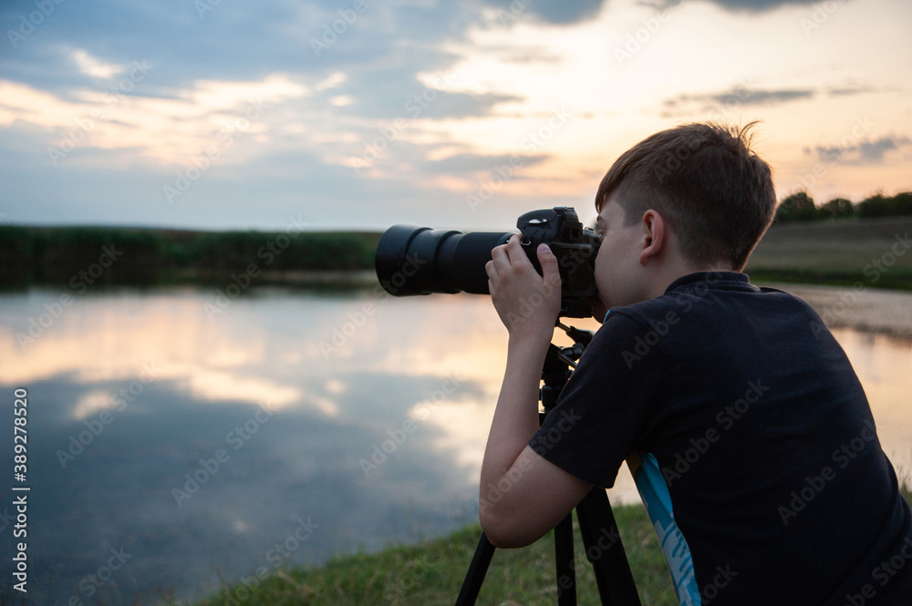 Obraz premium Photo of a boy holding a camera and taking some photos