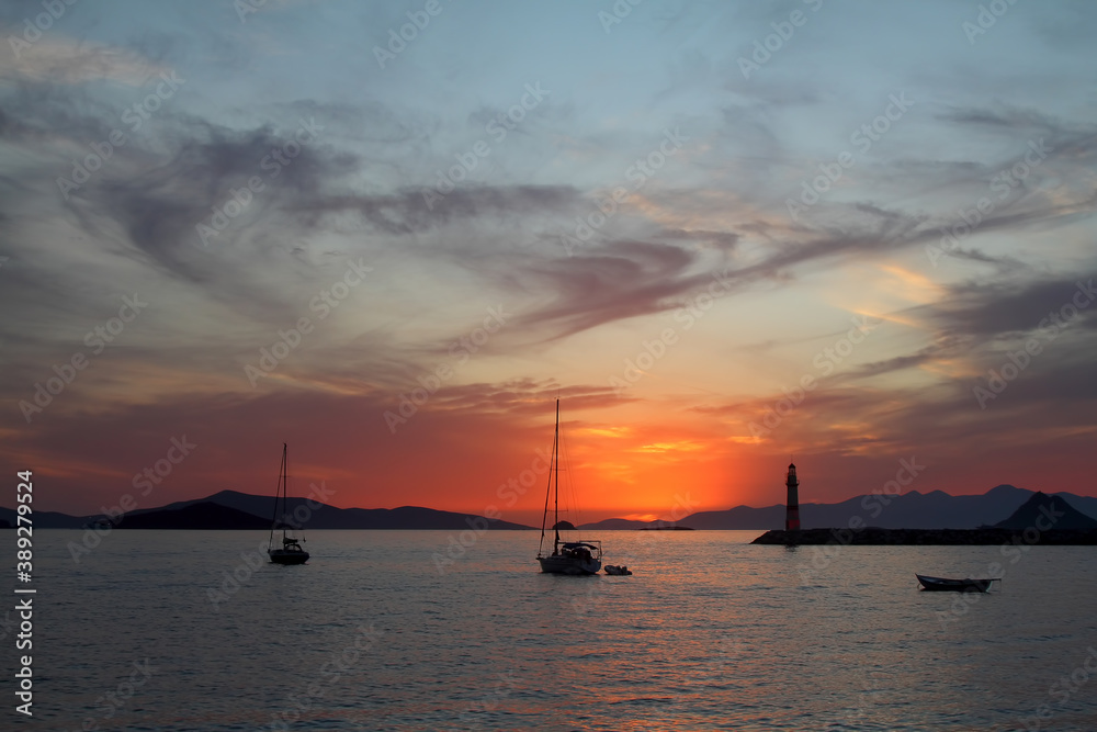 Seascape at sunset. Lighthouse on the coast. Seaside town of Turgutreis and spectacular sunsets	

