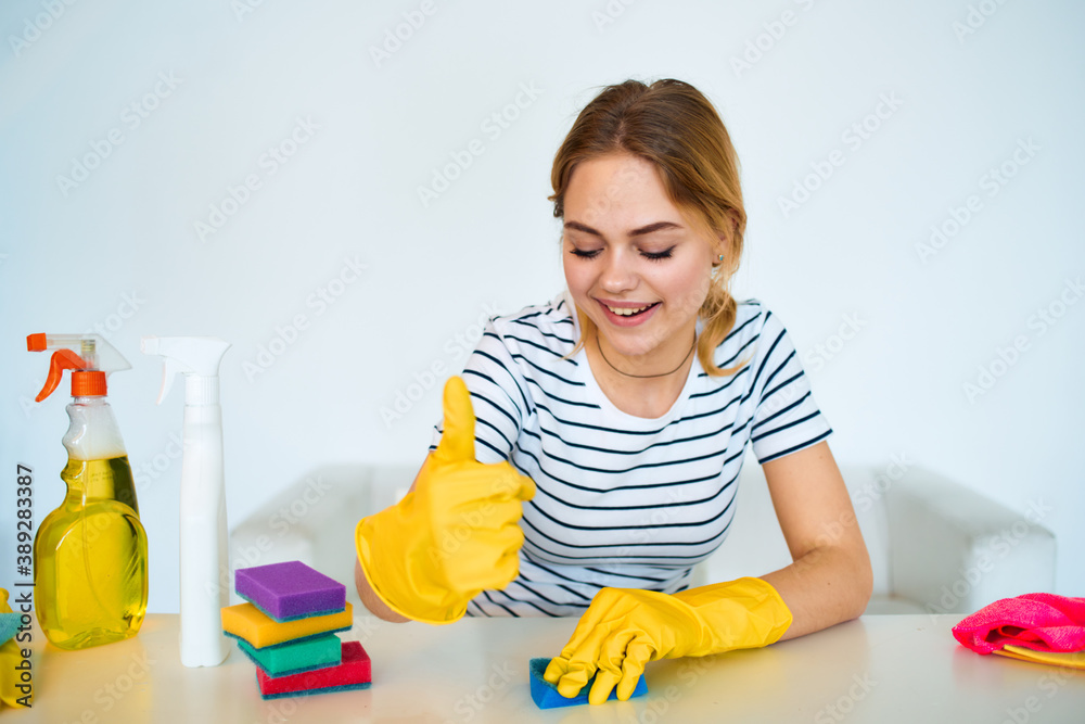 Cleaning lady in rubber gloves sits at the table cleaning tools service lifestyle Cleaning lady in rubber gloves sits at the table cleaning tools service lifestyle