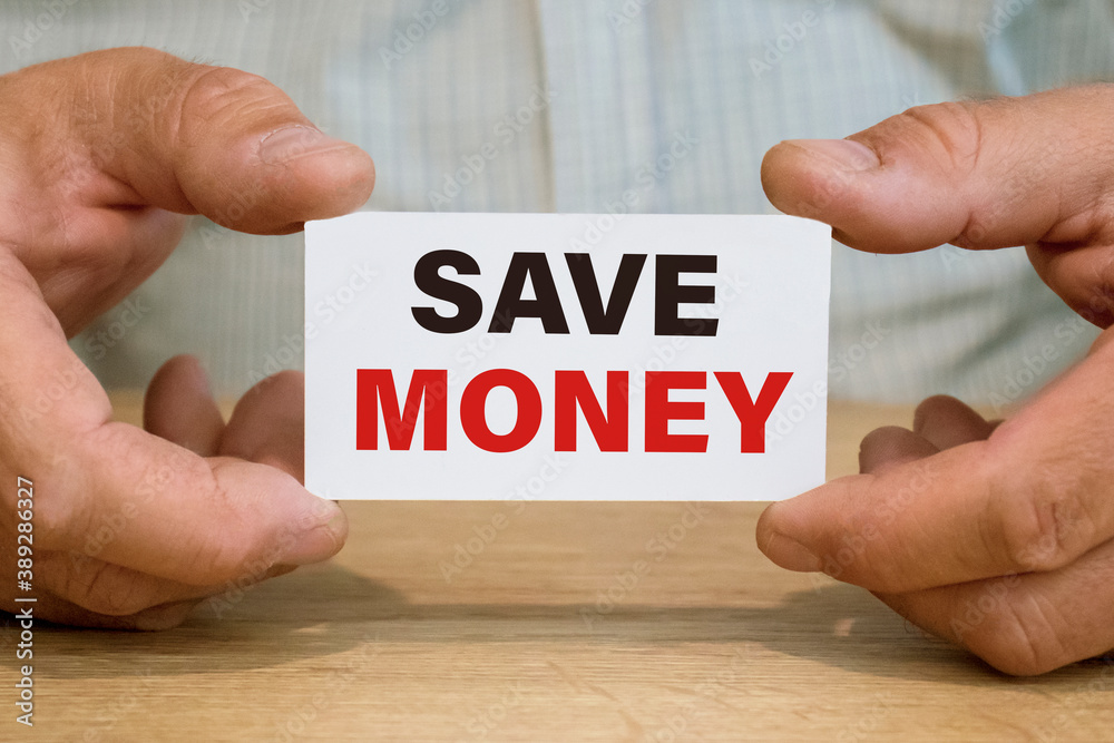 A business man holds in his hand a business card with the inscription SAVE MONEY. Business concept