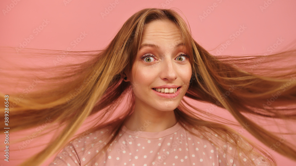 Fototapeta premium Portrait of excited young beautiful caucasian brunette dancing on pink background. High quality photo