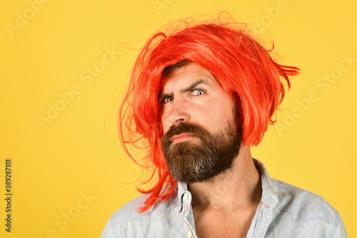 Serious man in color wig. Serious bearded man looking at camera. Portrait of serious man. Isolated. Wig. Colorfull hair.