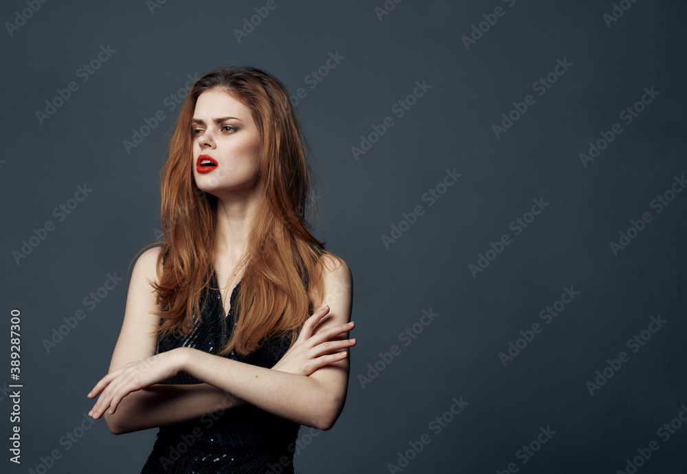 Naklejka premium Portrait of a woman in a black dress gesturing with bright makeup emotions with her hands