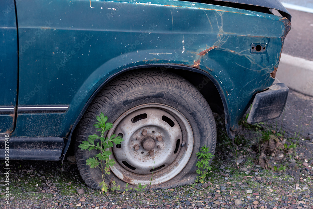 Old car with rust on the body and deflated wheels. Old car with rust on the body and deflated wheels.
