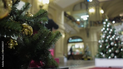 A Christmas tree decorated with Golden and black balloons stands in the lobby of the shopping center