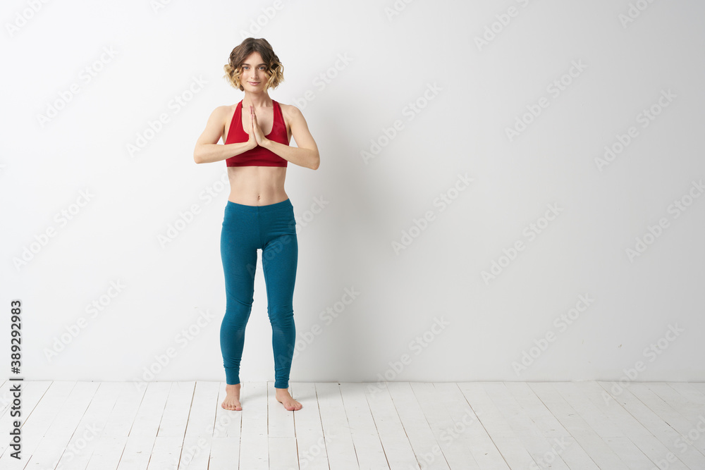 A woman in full growth In a bright room yoga meditation is engaged in sports A woman in full growth In a bright room yoga meditation is engaged in sports